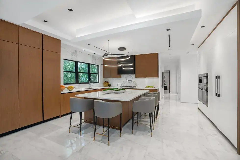 Casa Exumas kitchen with walnut cabinetry, a marble island and four counter stools