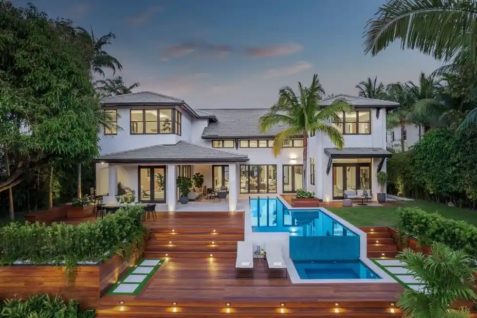 Casa Exumas at blue hour with Ipe deck lights leading to a lit pool and spa