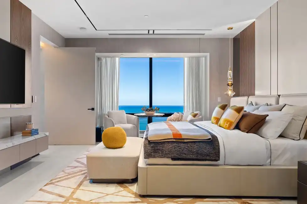Lower PH66 bedroom with a slatted wood wall, an upholstered bed and a window onto open water