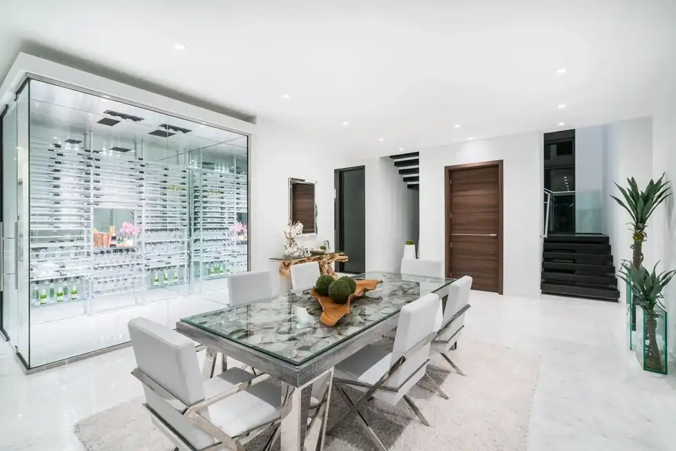 Casa Pinecrest dining room in front of a glass-walled wine cellar